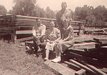 Frank, Mabel, Hazel and Bob Estel (standing) by lumber